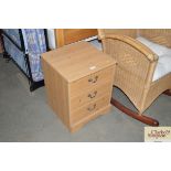 A pine effect three drawer bedside chest
