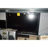 A Sony Bravia flat screen TV with remote control