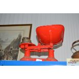 A set of red painted kitchen scales and weights