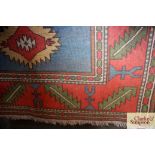 An approx 5'6" x 4' blue and red patterned rug