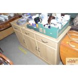 An oak effect sideboard fitted three drawers