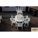 A plastic garden table with a set of six chairs, a