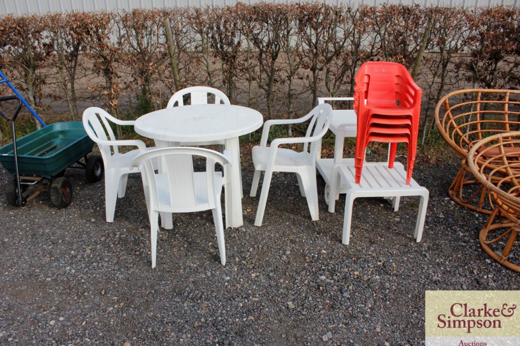 A plastic garden table and four chairs together wi