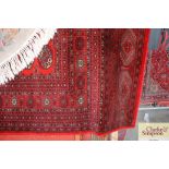 An approx 12' x 9' red patterned Bacara rug