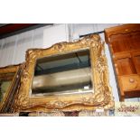 A large gilt framed bevel edged wall mirror, frame