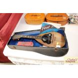 A mandolin in fitted case; and a harmonica