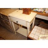 A cream side table with single drawer and under ti