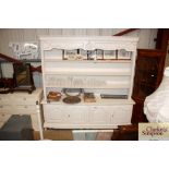 A large white painted dresser with open shelves an