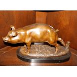 A bronze study of a pig on oval faux marble base,