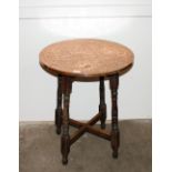 A circular copper topped occasional table raised o