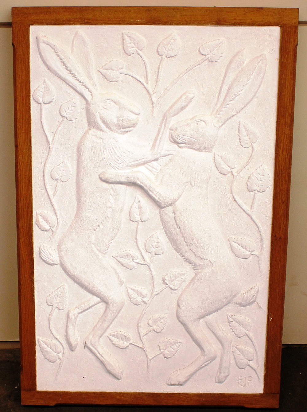 A decorative white plaster wall plaque, depicting