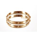 A 9ct gold snap bangle with foliate engrave decora