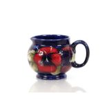 A Moorcroft "Pansy" pattern cream jug with deep ma