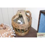 A French green glass jar in wicker basket