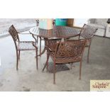 A brown painted metal garden table and four matchi