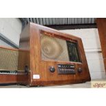 A vintage walnut cased radio with Bakelite handles