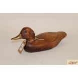 A wooden decoy duck with brass beak