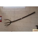 A three prong rustic wooden hedge fork