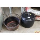 A black enamel cooking pot with lid and metal sw