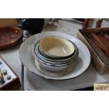 A large enamel pan and a quantity of enamel bowls