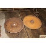 Two circular cast iron pig troughs