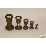 A graduated set of four brass bell weights and a