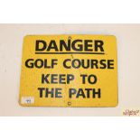 A metal sign "Danger Golf Course Keep To Path