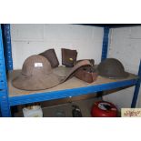 Two vintage military tin helmets; Sam Brown belt
