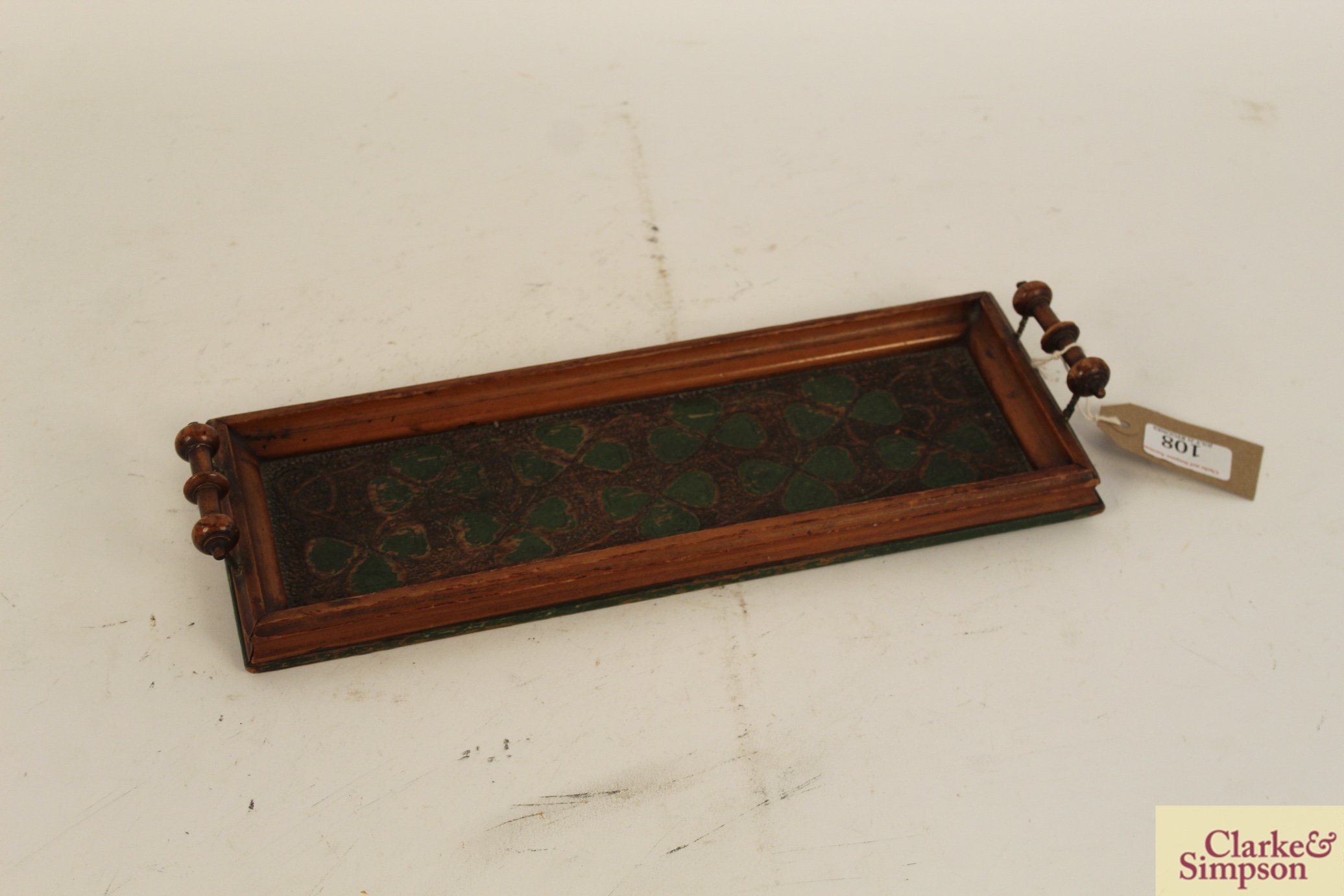 A small wooden two handled tray with clover leaf d