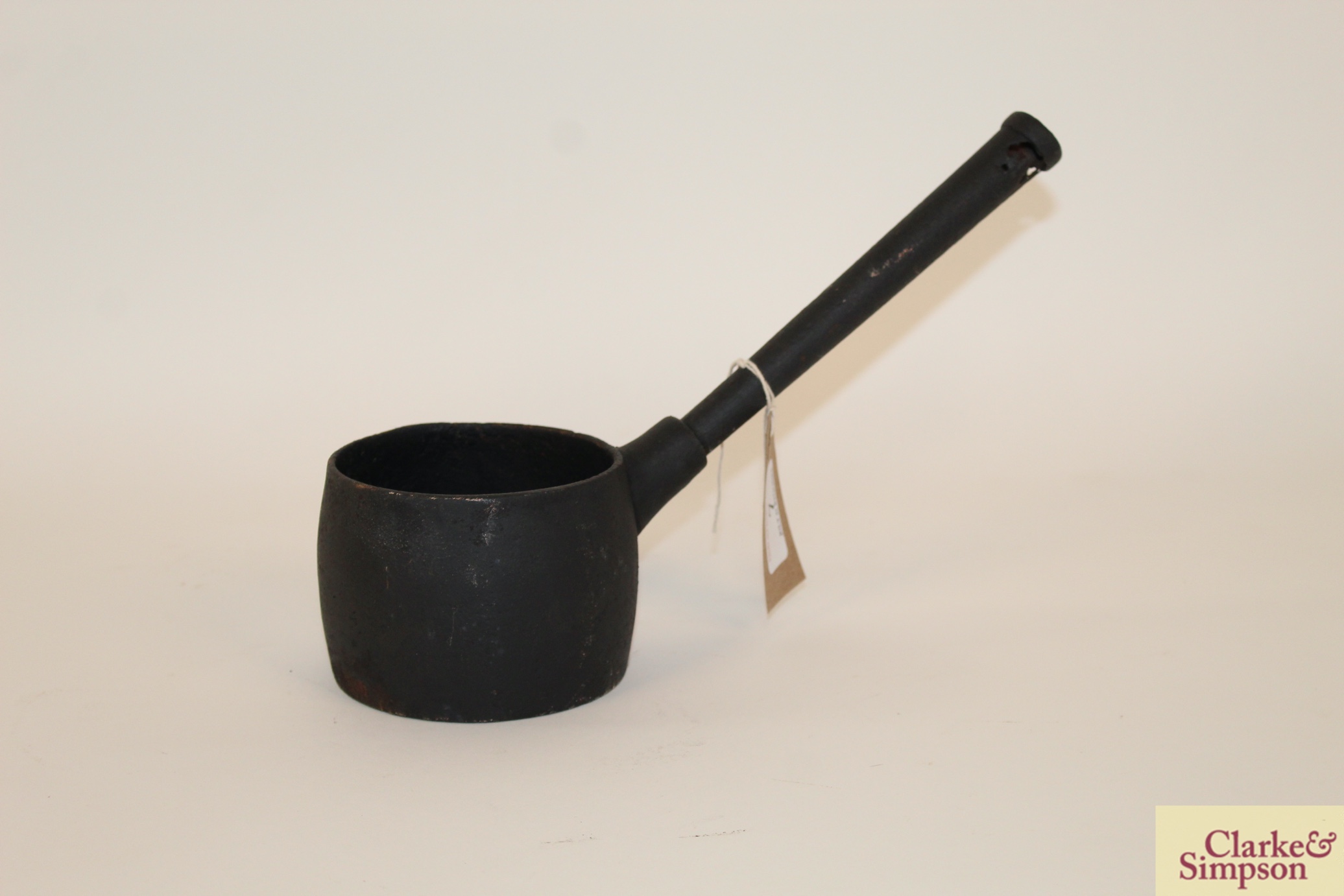 A small vintage cast iron saucepan having rounded