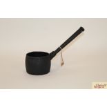 A small vintage cast iron saucepan having rounded
