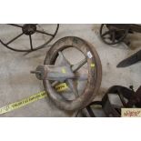 An old wooden and metal rimmed wheelbarrow wheel