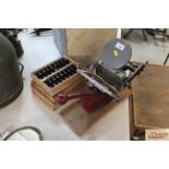 A hand printing press with four trays of printers