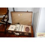 A vintage suitcase and contents of miscellaneous e