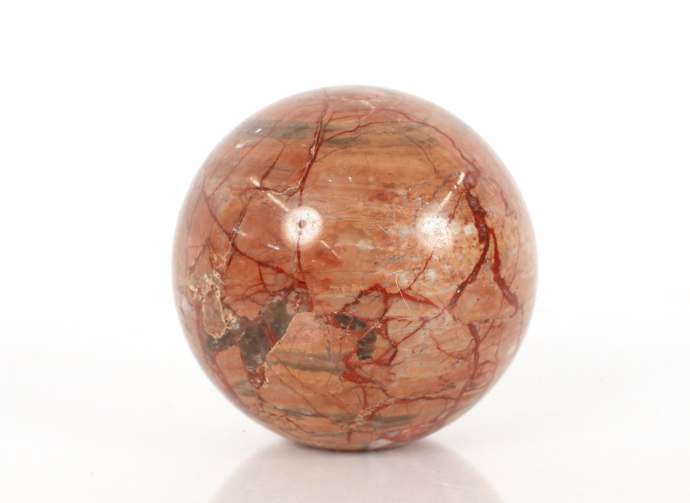 A veined marble paperweight, in the form of a sphere