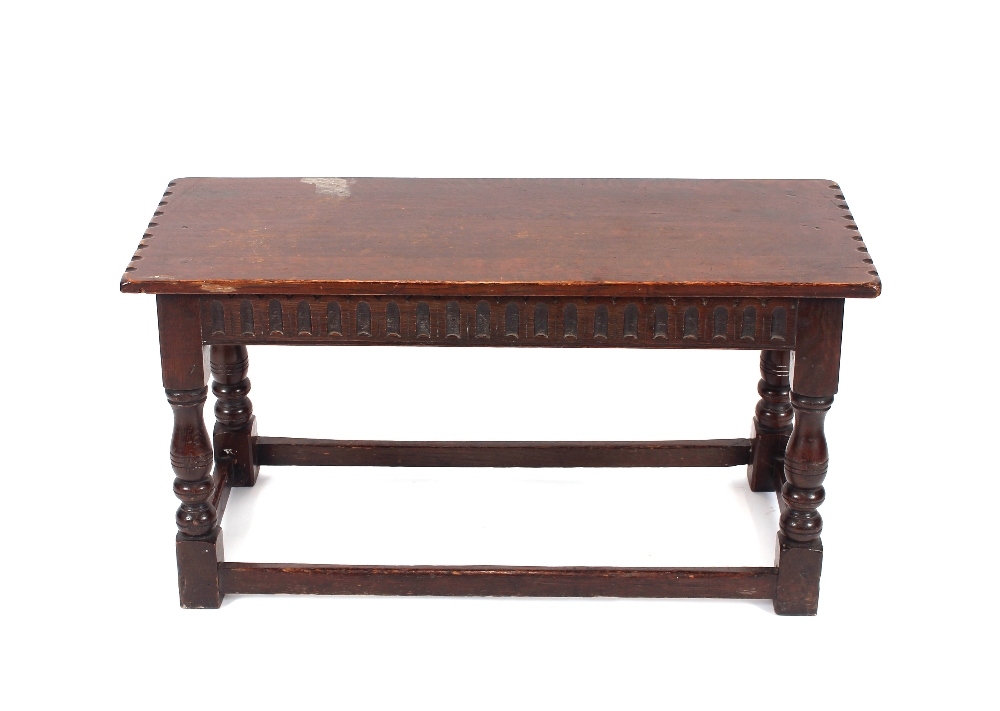 A carved oak joint stool, raised on baluster turned supports united by stretchers, 97cm wide