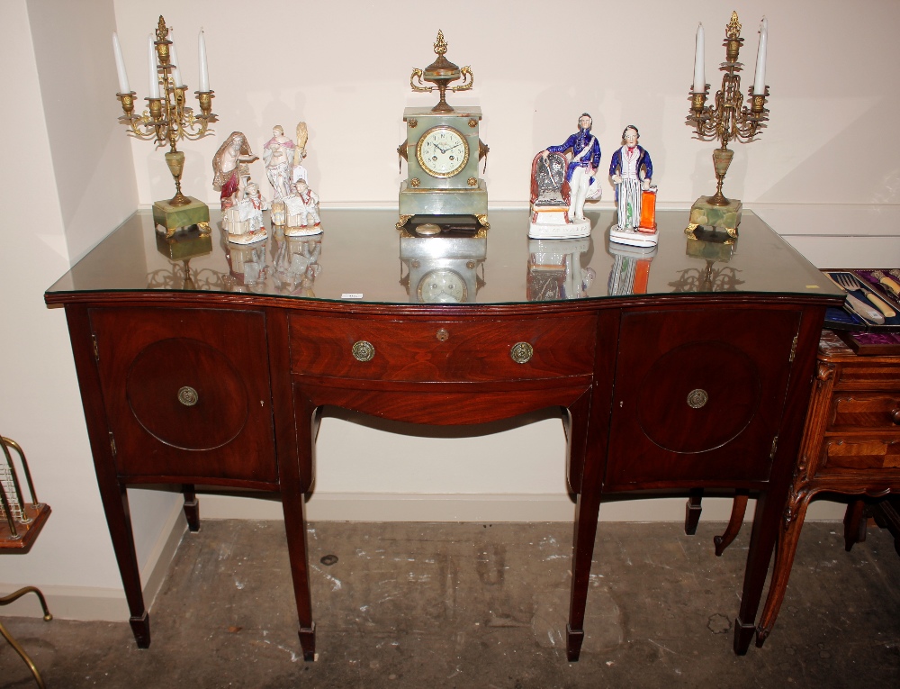 A late 19th / early 20th century mahogany serpentine fronted sideboard, fitted central cutlery