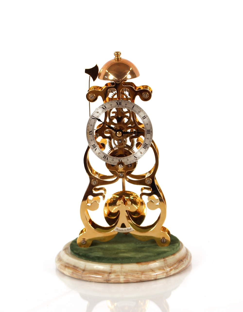 A brass skeleton clock, by Thwaites & Reed Ltd, under glass dome and set on onyx base, striking on a