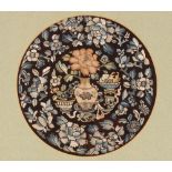 A circular Chinese embroidered panel, depicting vases of flowers in amongst a foliate border, 23.5cm