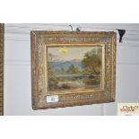 A gilt framed print depicting a landscape s