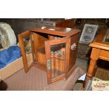 An oak and glass fronted smokers cabinet