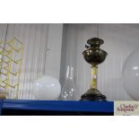 A brass oil lamp with glass chimney and milk glass