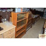 A light oak sectional bookcase enclosed by sliding