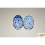 A pair of small blue pottery pepperettes