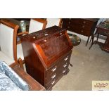 A reproduction mahogany bureau fitted three drawer