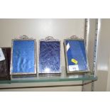 A set of three white metal easel photograph frames