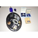 An ebony oval dressing table tray and contents of