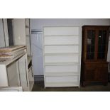 A white painted open fronted bookcase