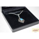 A boxed silver and marcasite and blue opal pendant