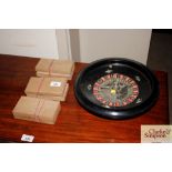 A roulette wheel and three boxes of counters